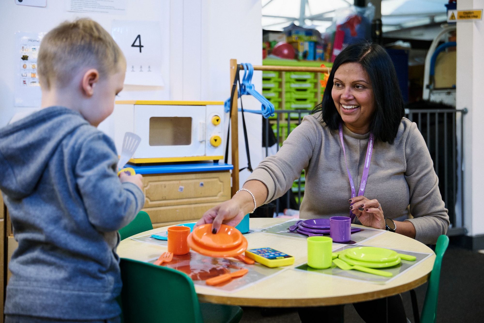 Teacher setting a table with a child